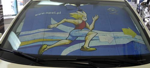 Przednia szyba Corsy 2011 - poster z biegaczem i pióra wycieraczek Flat Blade